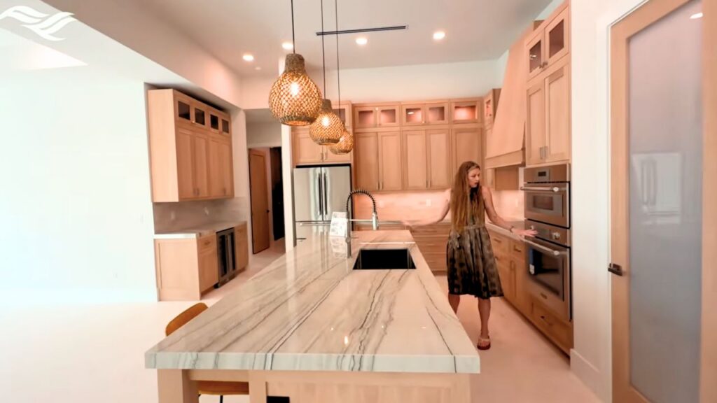 Susan Milner touring the kitchen of a custom luxury home in Cape Coral